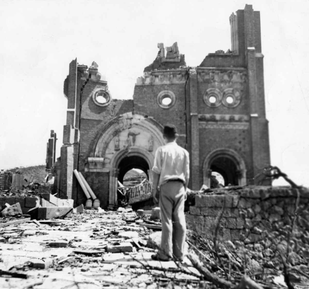 A man stands in front of Urakami Cathedral, which was left in ruins after the bombing, in a photo taken in September 1945. (ACME)