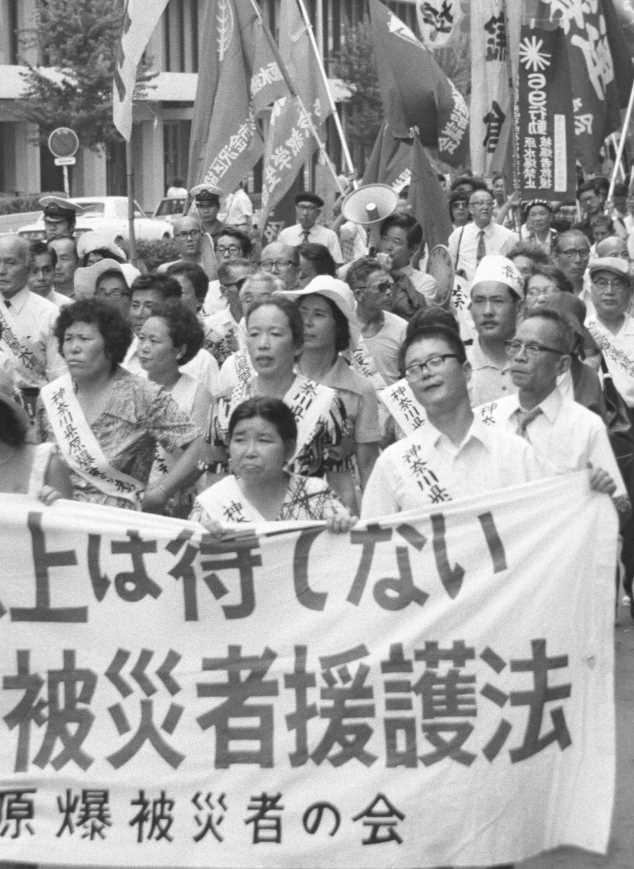 Members of the Japan Confederation of A- and H-Bomb Sufferers Organizations protest outside the U.S. Embassy in Tokyo on Aug. 2, 1974, 
          calling for new legislation for survivors as well as an anti-nuclear international accord. (Kyodo)