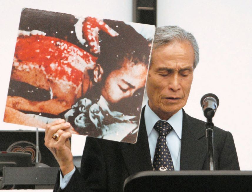 Holding a photo of his own injuries sustained in the Aug. 9, 1945, atomic bombing of Nagasaki, 
          Sumiteru Taniguchi speaks about his experience at a review conference of the Nuclear Non-Proliferation Treaty in New York in May 2010. (Kyodo)