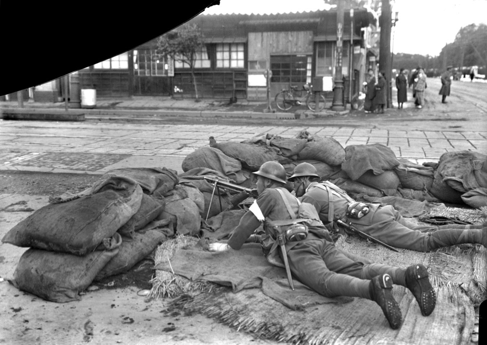 青山1丁目付近で機関銃を構える鎮圧部隊。左上部分は写真が破損している=1936年2月26~29日の間