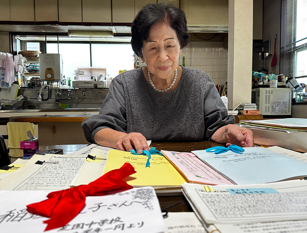 子どもたちが送ってくれた感想文を見る稲垣さん