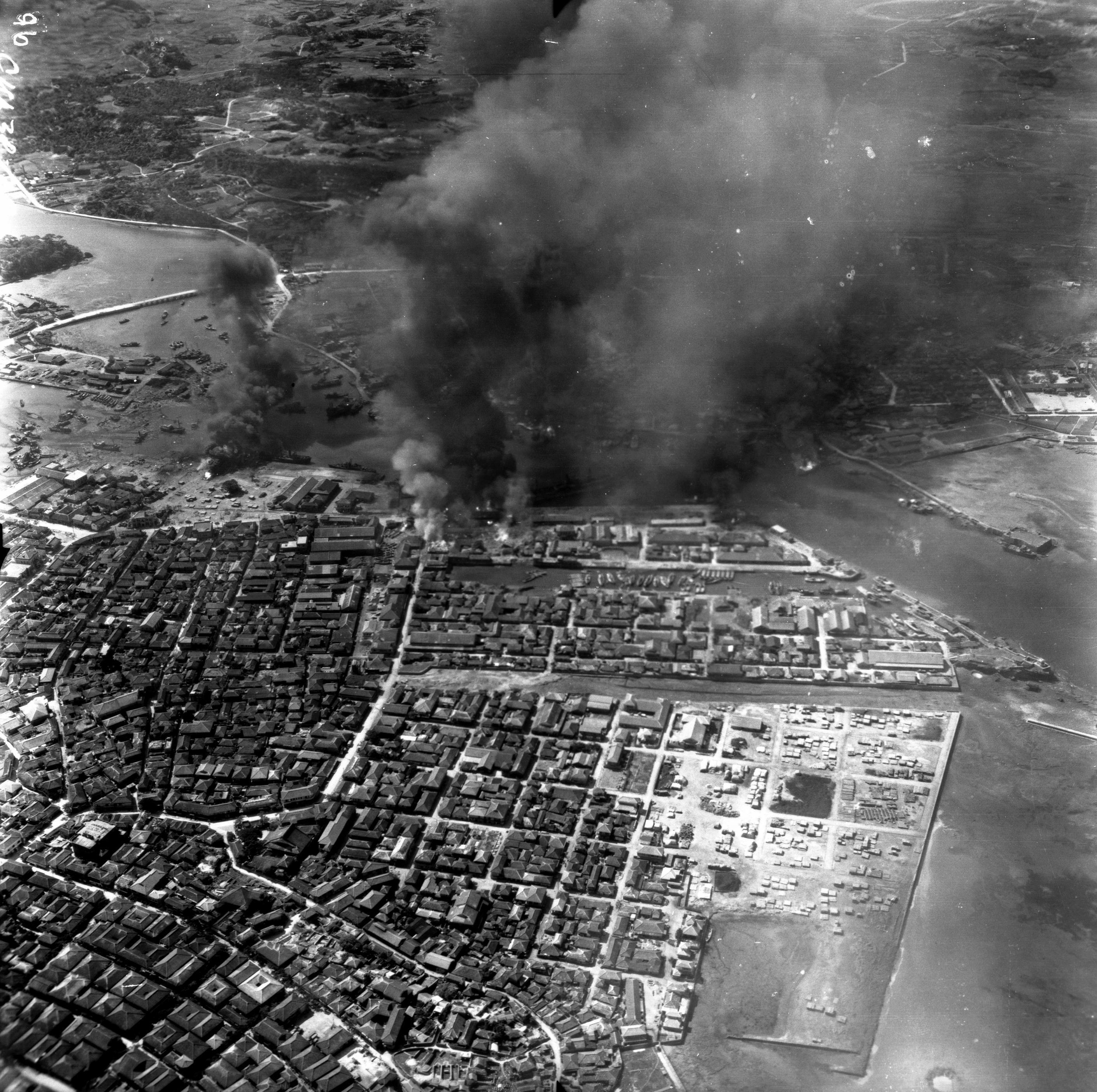 アメリカ軍が撮影した、１０月１０日の空襲で煙を上げる那覇市の市街地（沖縄県公文書館提供）
