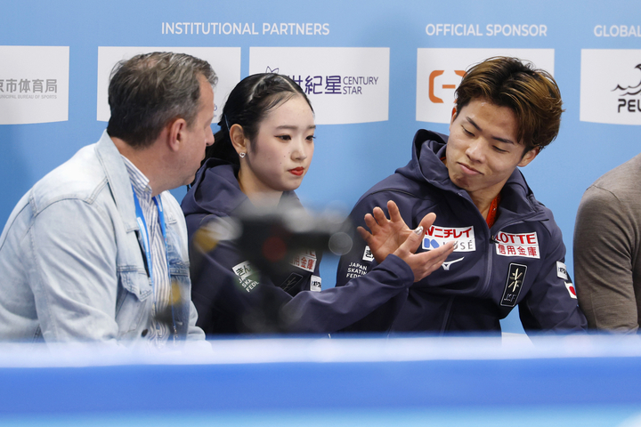 ペアSPの得点を確認し、タッチを交わす長岡柚奈(中央)、森口澄士組=北京(共同)