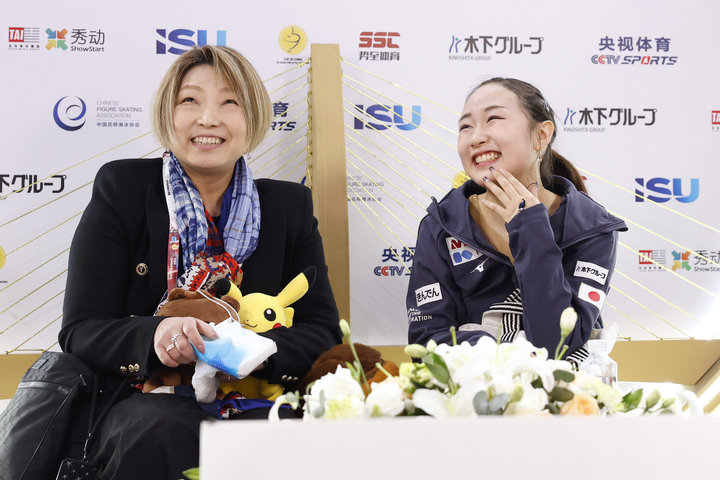 女子SPの得点を確認し、笑顔の松生理乃。左は本郷裕子コーチ=重慶(共同)