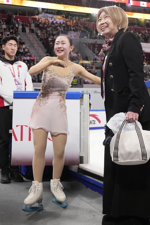 女子フリーの演技を終え、本郷裕子コーチ(右)に迎えられる松生理乃=重慶(共同)