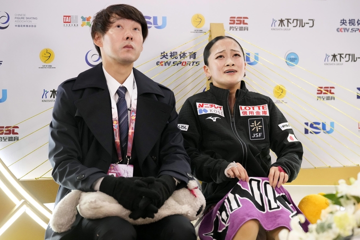 女子フリーの得点を確認し、感極まる渡辺倫果。左は中庭健介コーチ=重慶(共同)