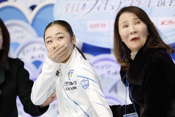 女子SPの得点を確認し、驚く島田麻央。右は浜田美栄コーチ=国立代々木競技場