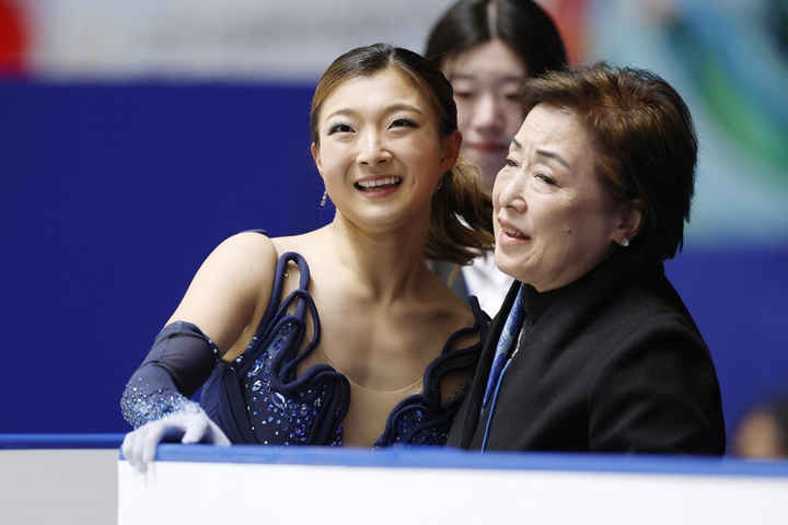 女子SPの演技を終え、中野園子コーチ(右)に迎えられる坂本花織=国立代々木競技場