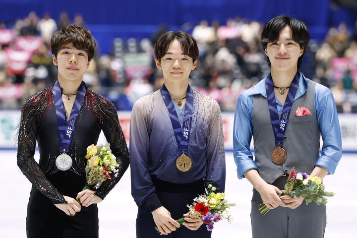 フィギュアスケートの全日本選手権で、2年連続2度目の優勝を果たしミラノ・コルティナ冬季五輪代表に決まった鍵山優真。左は2位の佐藤駿、右は3位の三浦佳生=20日、東京・国立代々木競技場