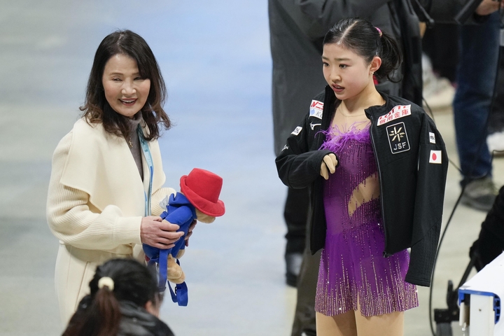 女子SPの演技を終え、浜田美栄コーチ(左)に迎えられる千葉百音=北京(共同)