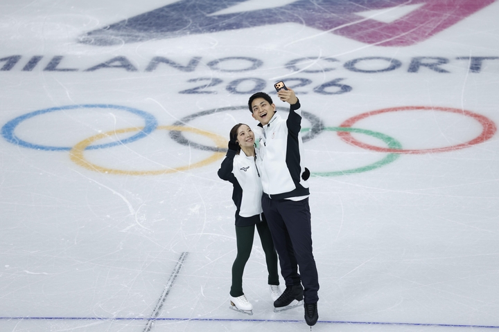 公式練習で自撮りするペアの三浦璃来(左)、木原龍一組=ミラノ(共同)