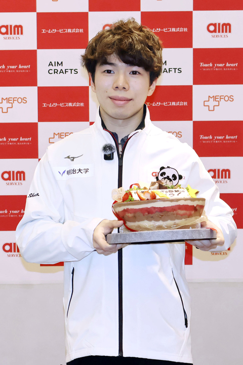 　所属先の社員交流会で贈られたケーキを手に、撮影に応じるフィギュアスケート男子の佐藤駿＝３日、東京都内