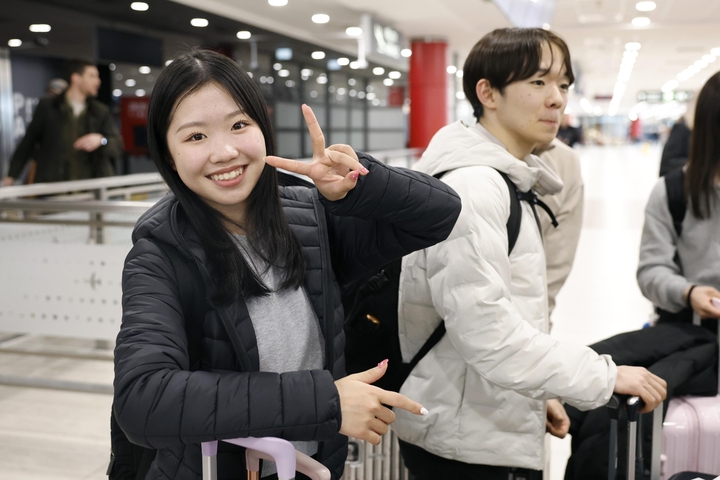 プラハの空港に到着したフィギュアスケート女子の中井亜美。右は男子の鍵山優真=23日(共同)