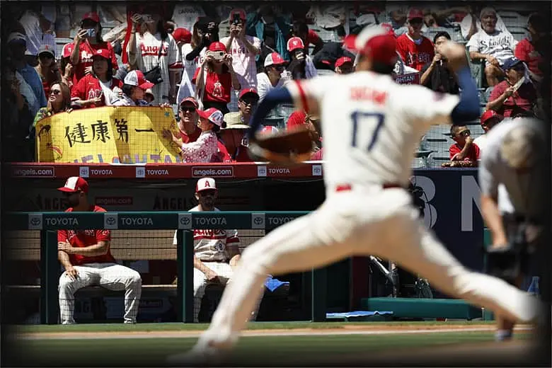 Shohei Ohtani delivering a powerful pitch and the worried fans.