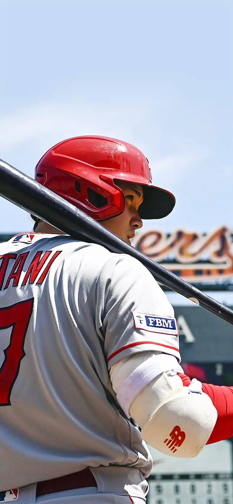 Shohei Ohtani with a bat on his shoulder and a sharp gaze.